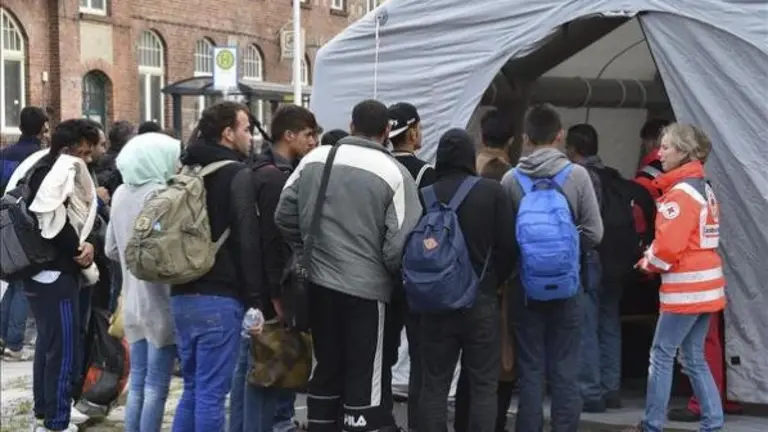 Refugiados sirios hacen cola hoy en una tienda de campa&ntilde;a de la Cruz Roja para un registro m&eacute;dico tras llegar a Eisenhuettenstadt (Alemania). EFE