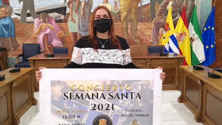 Concejala de Cultura con cartel anunciador