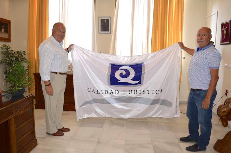 Antonio Fernandez y Jose Maria Gomez sostienen la Bandera Q de Calidad Turística 2018